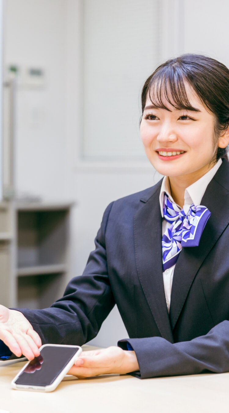 ショップでスマートフォンについて、お客様に説明する女性