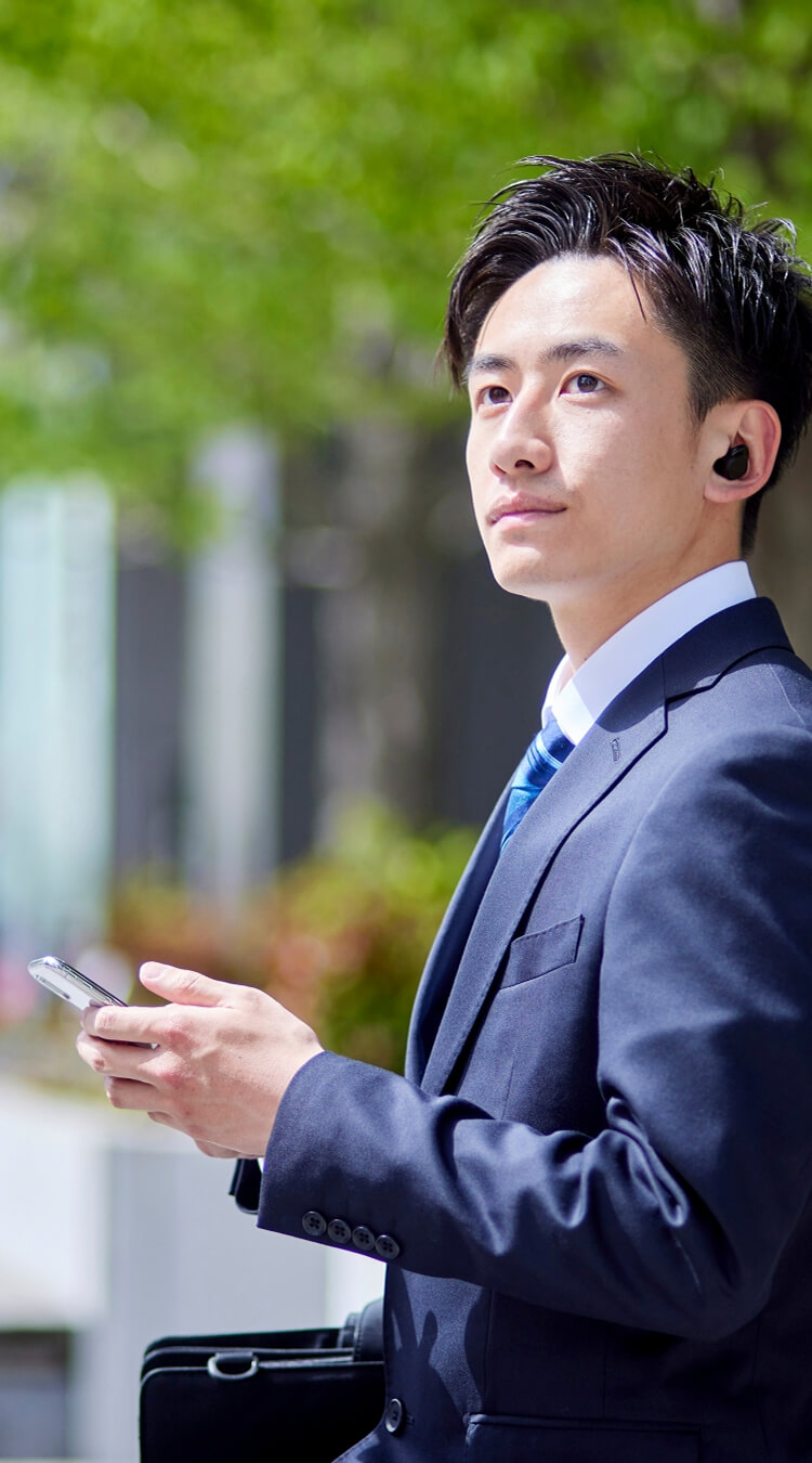 スマートフォンを持ってオフィス街にいる男性